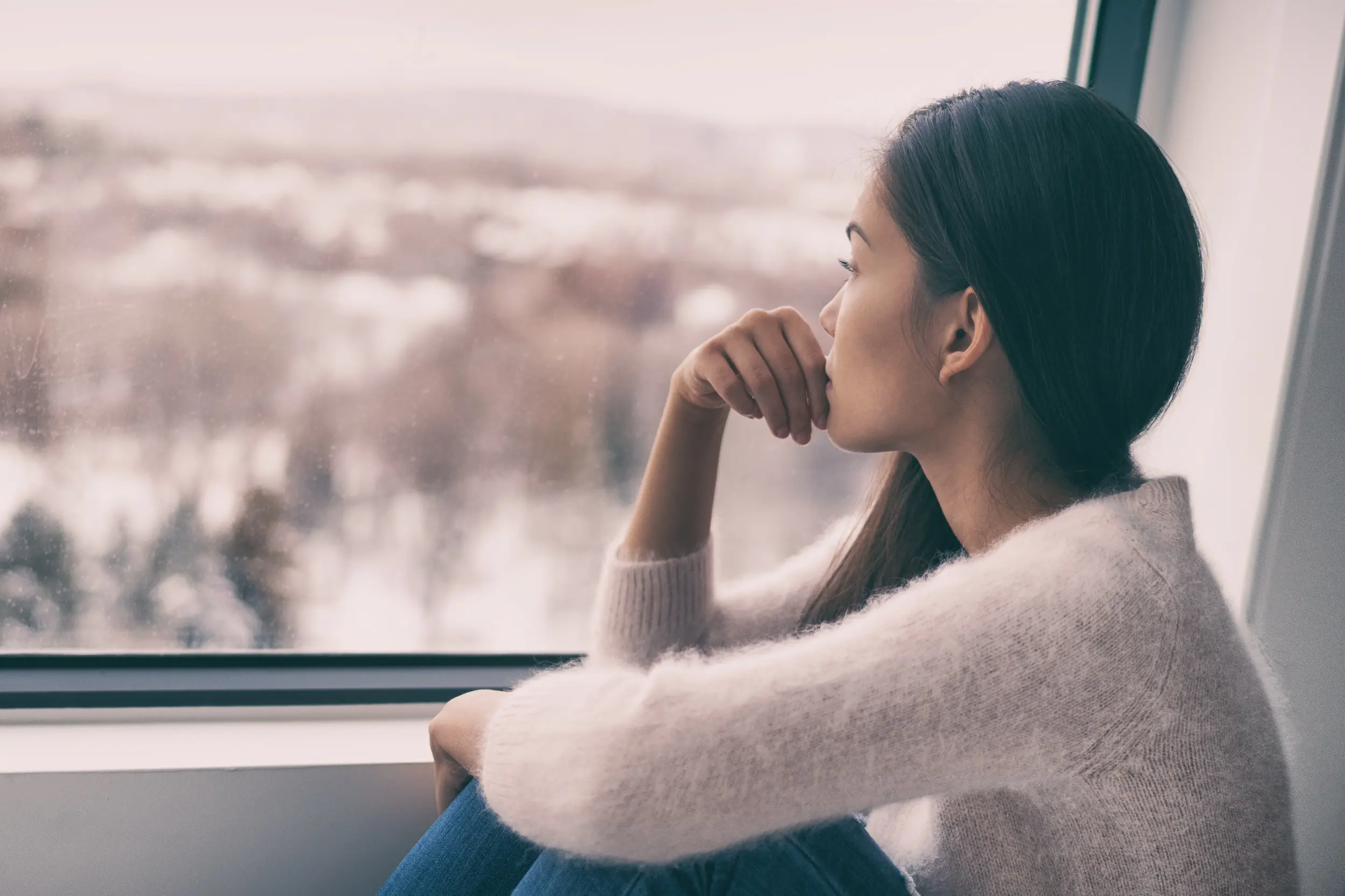 Winter Depression Seasonal Affective Disorder Mental Health Woman Sad Comtemplative Looking Out The Window Alone.